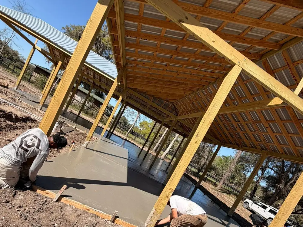 Concrete crew finishing a slab inside a timber frame
