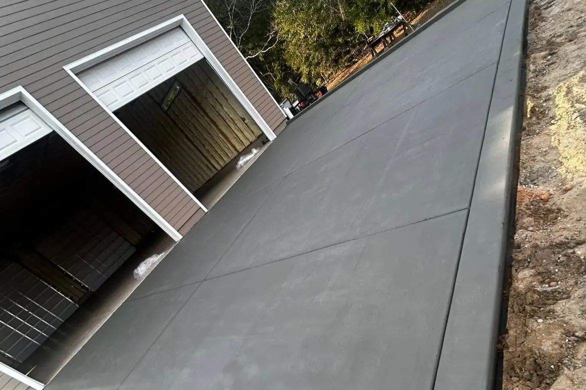 Finished broom-swept concrete driveway running up to barn doors