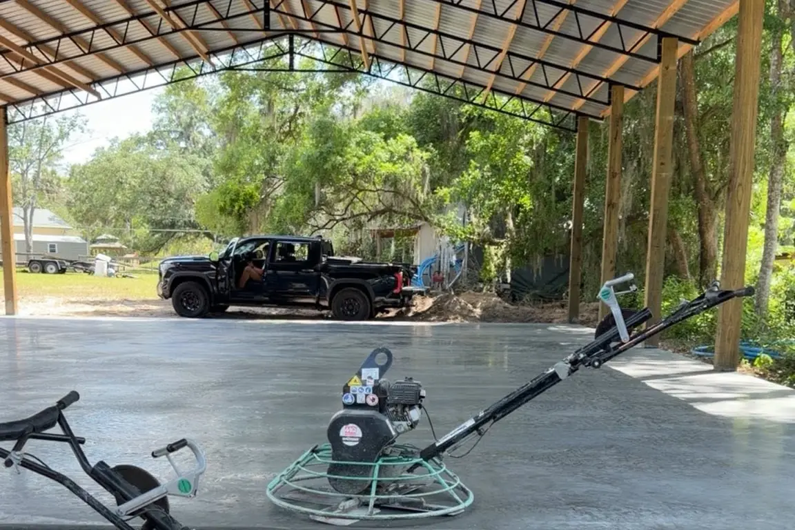 Ride-on power trowel sitting on a green slab, ready for the finish pass